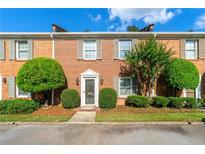 Charming brick townhome featuring meticulously landscaped front yard and elegant entryway at 1622 Executive Park Ne Ln, Atlanta, GA 30329