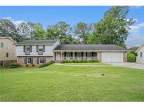 Charming home with a brick and white facade, a well-manicured lawn, and a welcoming front porch at 2855 Cedar Canyon Ct, Atlanta, GA 30345