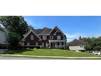 Charming two-story brick home featuring a manicured lawn and inviting front porch at 3305 Millwater Xing, Dacula, GA 30019
