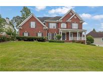 Charming two-story brick home with a well-manicured lawn, covered porch, and black shutters at 3305 Millwater Xing, Dacula, GA 30019