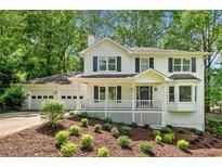 Charming two-story traditional home with a welcoming front porch and a well-manicured, landscaped front yard at 3078 Milford Chase Sw, Marietta, GA 30008