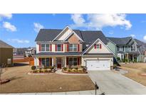 Charming two-story home with red shutters, manicured lawn, and a two-car garage at 2430 Redbud Meadow Ln, Douglasville, GA 30135
