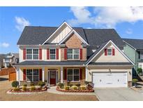 Charming two-story home featuring manicured landscaping and a welcoming front porch, perfect for suburban living at 2430 Redbud Meadow Ln, Douglasville, GA 30135