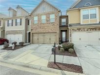 Charming townhome with a two-car garage, manicured landscaping, and a welcoming front entrance at 3318 Sardis Bend Dr, Buford, GA 30519