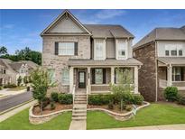 Charming two-story home with a brick facade, landscaped yard, and a welcoming covered front porch at 4831 Miller Hill Rd, Buford, GA 30518