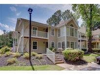 Inviting condo exterior with balcony, landscaped garden, and natural light at 307 Berkeley Woods Dr, Duluth, GA 30096