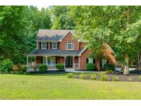 Charming two-story brick home with a welcoming front porch and meticulously landscaped front yard at 2995 Aspen Ridge Ct, Snellville, GA 30078