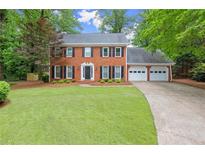 Charming two-story brick home with well-manicured lawn and a three-car garage at 4504 Reva Ne Way, Marietta, GA 30066