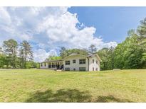 Bright two-story home featuring a well-manicured lawn, complementing trees, and freshly painted exterior at 218 Ward Rd, Ellenwood, GA 30294