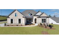 Charming brick home featuring manicured lawn, stone accents, and a welcoming front porch at 227 Laurel Vista Dr., Canton, GA 30114