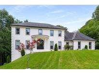 Stunning two-story white brick home featuring a circular entryway and meticulously landscaped front yard at 2912 Vinings Forest Se Way, Atlanta, GA 30339