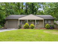 Charming home featuring a well-manicured lawn, complemented by lush greenery, offering a welcoming curb appeal at 2343 Poplar Springs Ne Dr, Brookhaven, GA 30319