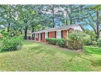 Charming one-story brick home with well-maintained lawn and mature trees at 5868 Ash St, Forest Park, GA 30297