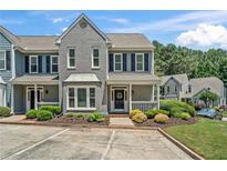 Charming two-story townhome with gray brick and siding, complemented by a well-maintained front yard at 1201 Bridle Path, Marietta, GA 30068