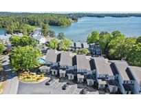 Stunning aerial view of lakeside condos with lush trees and community pool at 2300 Harbersham Marina Rd # 102, Cumming, GA 30041