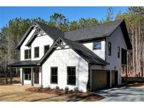 Beautiful, new two-story home with white siding, black trim, and a two-car garage with attractive landscaping at 3785 Pilgrim Mill Rd, Cumming, GA 30041