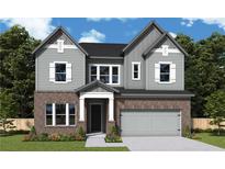Charming two-story home featuring a brick facade, gray siding, and an attached two-car garage at 4720 Briscoe Drive, Cumming, GA 30028