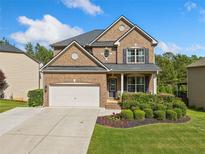 Beautiful brick two-story home with a well-manicured lawn, flower bed and a two car garage at 1925 Piedmont Cove Ln, Cumming, GA 30040