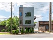 Contemporary three-story home featuring mixed brick and metal siding with black framed windows at 417 E College Ave # 102, Decatur, GA 30030
