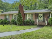 Charming brick home with well-maintained landscaping and a cozy front porch at 664 Mcburnette Ne Rd, Marietta, GA 30068