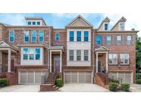 Charming brick townhome featuring a two-car garage and classic architectural details at 991 Sibley Ne Ln, Atlanta, GA 30324