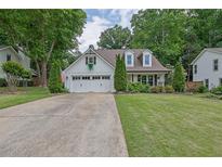 Charming one-story home with white siding, dormer windows, attached garage, and well-manicured lawn at 115 Ocee View Ct, Alpharetta, GA 30022