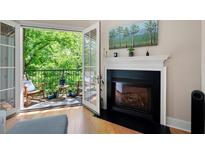 Bright living room with fireplace and balcony access showcasing outdoor views at 351 Washington Ne Ave # 205, Marietta, GA 30060
