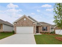 Charming one-story home featuring a brick facade, well-maintained lawn, and an attached two-car garage at 401 Village Ln, Fairburn, GA 30213