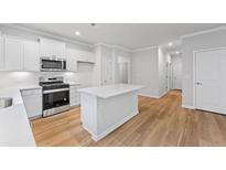 Modern kitchen featuring stainless steel appliances, white cabinets, and a center island at 401 Village Ln, Fairburn, GA 30213