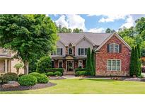 Beautiful two-story home with well-manicured lawn, brick facade, and mature trees offering great curb appeal at 5025 Savannah Run, Cumming, GA 30040