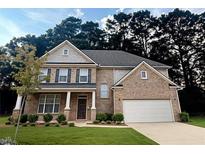 Beautiful brick two-story home featuring a two-car garage and well-manicured lawn at 1147 Halletts Peak Pl, Lawrenceville, GA 30044