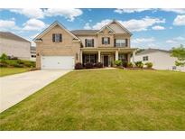 Beautiful brick two-story home with a well-manicured lawn and inviting front porch at 4832 Stone Way Path, Buford, GA 30519
