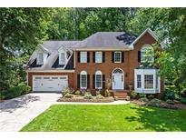 Stately brick home with lush front lawn, two car garage, and professionally landscaped flower beds at 763 Old Paper Mill Se Dr, Marietta, GA 30067