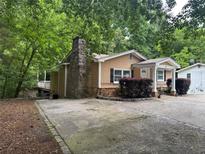 Charming home exterior featuring a stone chimney and inviting front porch at 2030 Carr Rd, Conyers, GA 30012