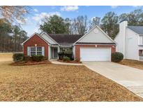 Charming single-story home with a well-maintained lawn and a two car attached garage at 2457 Swan Lake Dr, Grayson, GA 30017