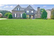 Stunning brick home with a well-manicured lawn and stone accents at 468 Scott Farm Dr, Powder Springs, GA 30127