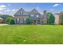 Charming two-story brick home with a stone chimney and a beautifully landscaped front yard at 468 Scott Farm Dr, Powder Springs, GA 30127