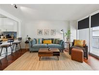 Stylish living room featuring a comfortable blue sofa, hardwood floors and lots of natural light at 620 Peachtree Ne St # 403, Atlanta, GA 30308