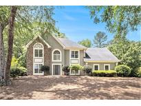 Charming home featuring stone accents, arched windows, manicured landscaping, and a well-maintained lawn at 1198 Larson Sw Ln, Marietta, GA 30064
