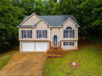 Charming two-story home with a well-manicured lawn, two-car garage, and inviting front porch at 130 Opal Ln, Carrollton, GA 30116
