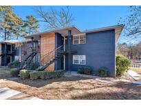 Charming exterior view with a blue brick facade, wood accent, and black iron staircases at 3137 Buford Ne Hwy # 11, Brookhaven, GA 30329