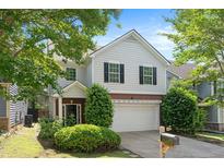 Charming two-story home features a well-manicured lawn, attached garage, and classic architectural details at 5712 Grande River Rd, Atlanta, GA 30349
