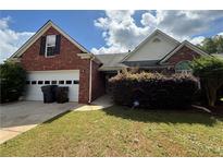 Traditional brick home featuring an attached two-car garage and a well-maintained lawn under a partly cloudy sky at 124 Sparkling Spring Trl, Mcdonough, GA 30252