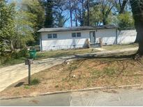 Charming single-story home with white brick, grassy front yard, and driveway at 1905 Robinhill Ct, Tucker, GA 30084