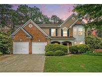 Charming two-story home featuring a manicured lawn, brick accents, and a convenient two-car garage at 2717 High Creek Run, Dacula, GA 30019