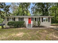 Charming single-story home with red front door and well-maintained landscaping at 3294 Renault Se Rd, Atlanta, GA 30354