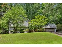 Charming two-story home with a well-manicured front lawn and mature trees offering shade and privacy at 3665 Pine St, Atlanta, GA 30340