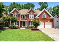 Charming two-story brick home with a manicured lawn, mature trees, and an attached two-car garage at 3944 Blustery Ne Way, Marietta, GA 30066