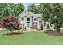 Charming two-story home with a well-manicured lawn, mature trees, and elegant landscaping at 4045 Bridle Ridge Dr, Suwanee, GA 30024