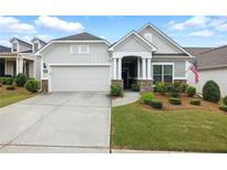Charming home featuring a two-car garage, well-manicured lawn, and inviting front porch at 5744 Cypress Bluff Ln, Hoschton, GA 30548